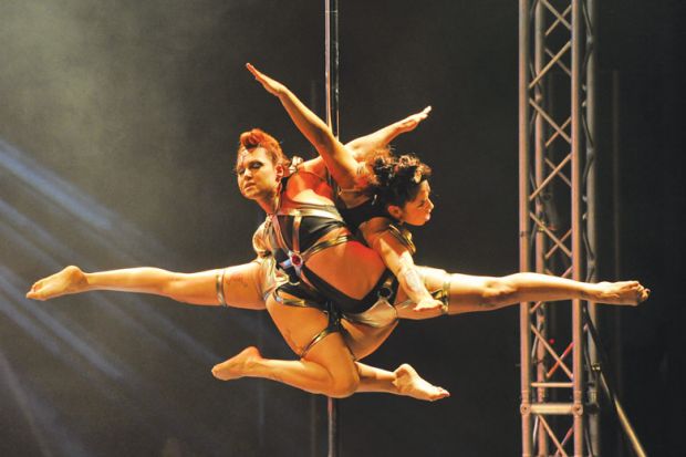 Two performers in the doubles International Pole Championship in Singapore perform together as a metaphor for two main universities of Singapore has brought together its largest and most established faculties.