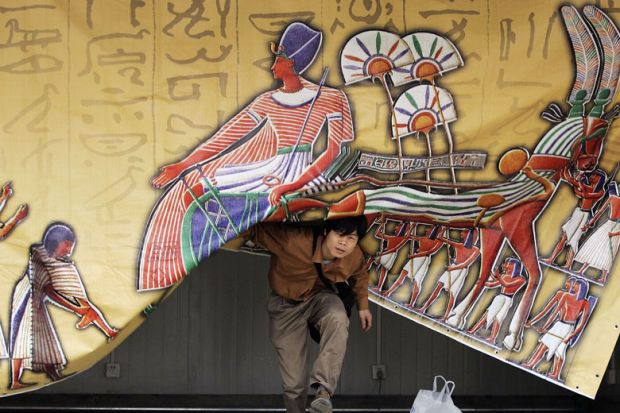Person appears from under a an Egypt- theme curtain in Beijing to illustrate Asia tipped to follow US lead with open access mandates