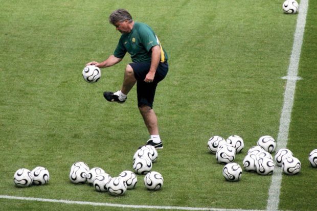 Australian national coach inspects the balls during a training session to illustrate Australian universities funded for unsolicited places