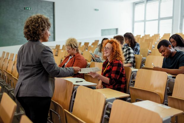 Teacher Handing Over Test Results to Her Students in the Classroom to illustrate I stopped taking class attendance personally – and feel better for it