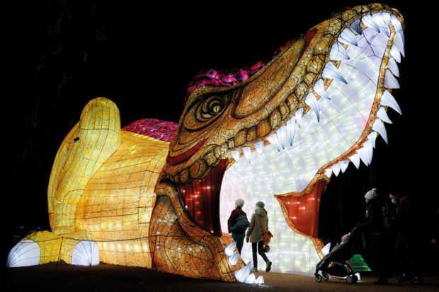 A giant illuminated sculpture of a creature with it's mouth open and people walking inside to illustrate It’s ‘feast or be eaten’ for France’s booming private HE sector