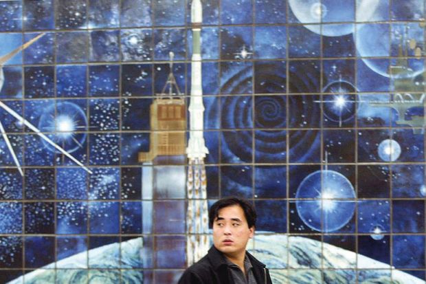 A man walks past a space mural depicting a rocket launch in Beijing, China to illustrate China’s Young Thousand Talents fails to attract ‘top’ scientists