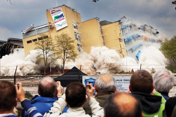 Residents watch a  controlled demolition in the Netherlands to illustrate Overseas student caps in limbo after Dutch government collapses