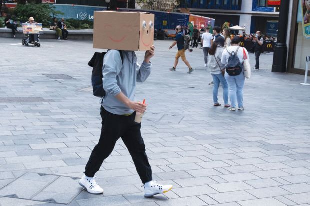 A man walks with a cardboard box on his head as a metaphor for In journal of taboo topics, anonymity is most daring