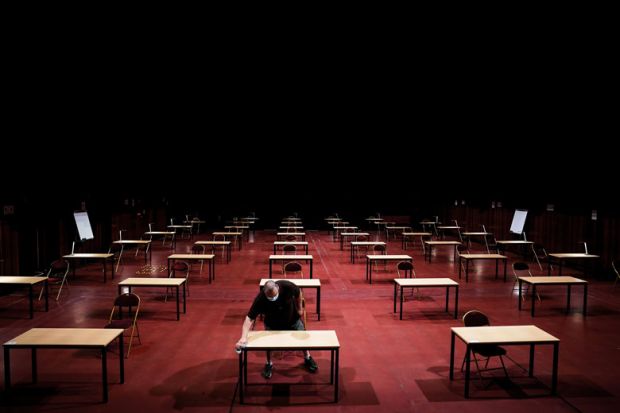 A man disinfects tables in an empty exam room as a metaphor for Is it time to rethink s tudent assessment?