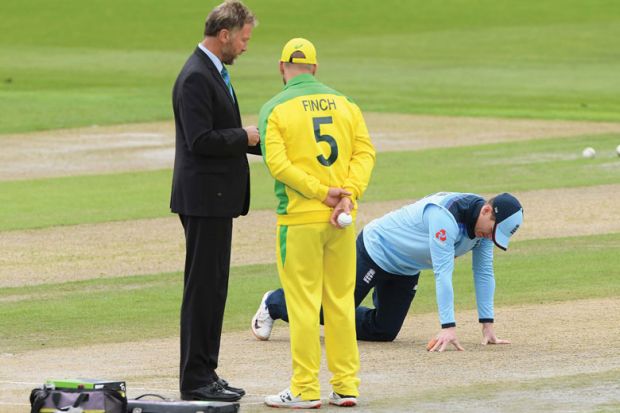 England captain Eoin Morgan inspects the pitch as match referee Chris Broad (l) chats with Australia captain Aaron Finch