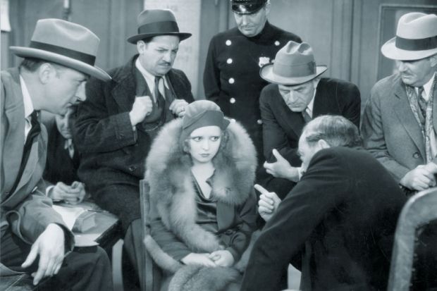 Actress Clara Bow (1905- 1965) is being questioned in a scene from the film 'No Limiit' to illustrate English voters quizzed on tuition fee preferences