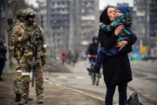  A woman holds and kisses a child next to a Russian soldier to illustrate Upsurge in defence research awakens disciplinary divisions