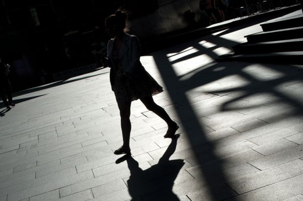 A shadow of a lady casts on the ground in Sydney to illustrate Covid exodus failed to stem sexual abuse on Australian campuses