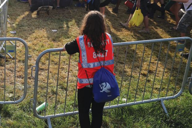 Security person holding gate at a festival