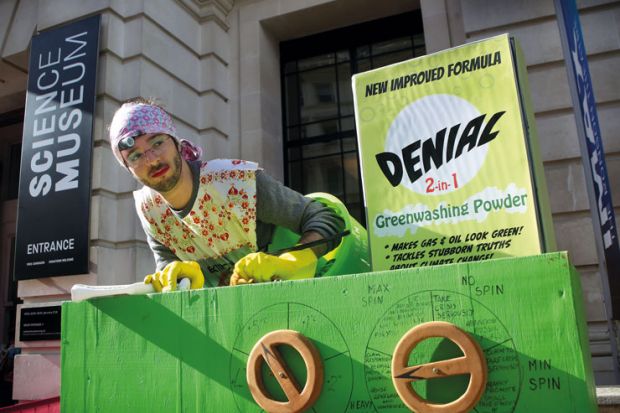 A protester dressed as a scrubber puts denial powder into the giant greenwashing washing machine during an extinction rebellion protest to illustrate Climate scientists fear loss of policy influence under Rees-Mogg