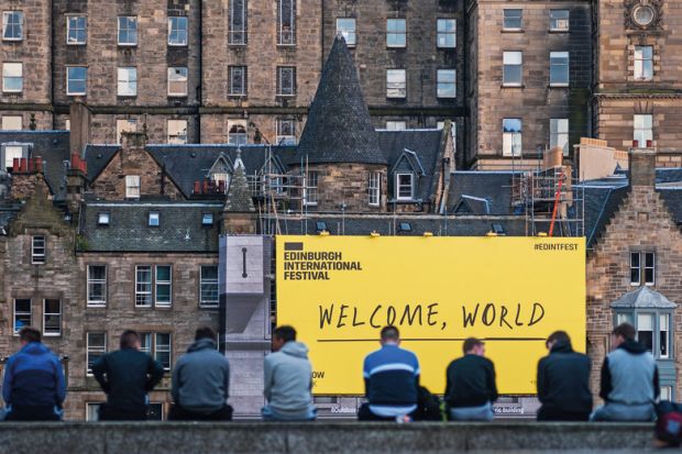 EDINBURGH, SCOTLAND - AUGUST 14: Citizen stand in front of the welcome sign of Edinburgh Festival Fringe on August 14, 2016 in Edinburgh, Scotland.