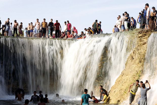 Egyptians enjoy a waterfall in Wadi El-Rayan