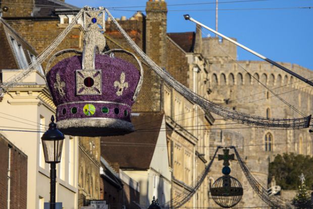 Windsor, UK - November 28th 2021 A Royal Crown Christmas decoration in the town centre of Windsor, with Windsor Castle in the background, in Berkshire, UK.