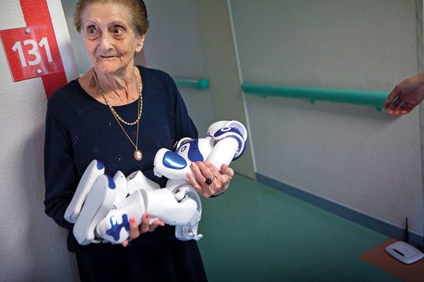 elderly woman holding robot