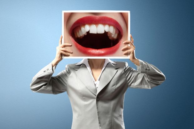 Woman holding photo of open mouth over face
