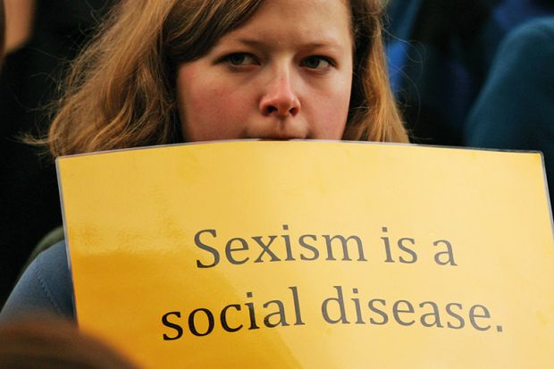 Woman holding sexism is a social disease sign
