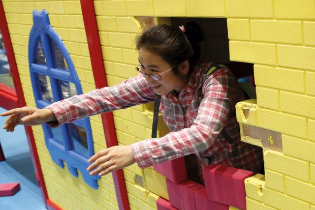 Woman playing with son at indoor playground, Beijing, China, 2015
