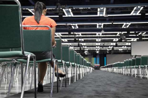 Woman sitting alone in empty conference centre