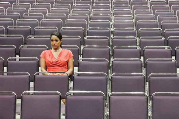 Woman sitting alone on empty lecture hall