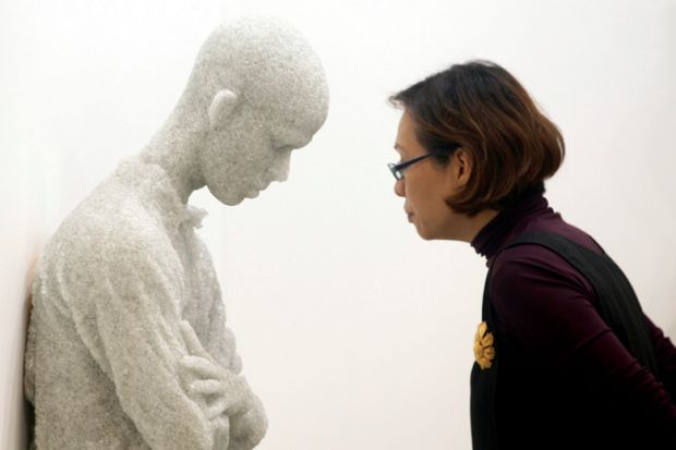 Woman viewing 'Figure with arms crossed' sculpture by Daniel Arsham, Singapore