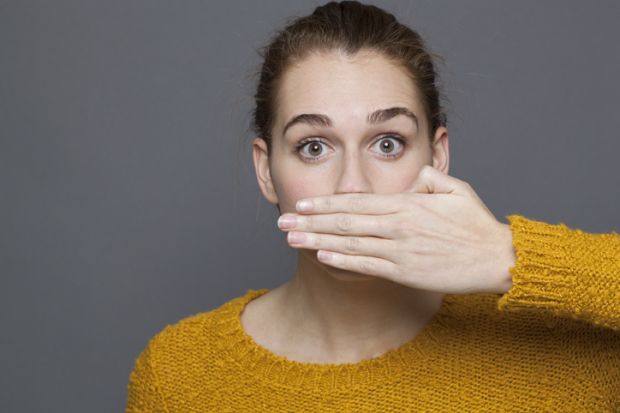 woman covering her mouth for silence