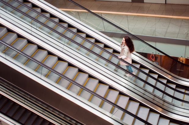 Woman going up on escalator