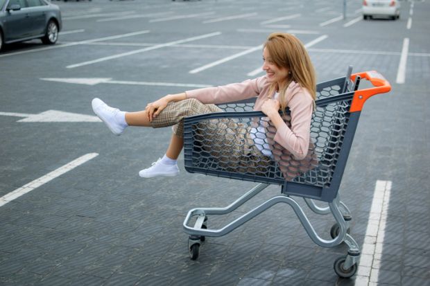 Woman sitting in shopping trolley