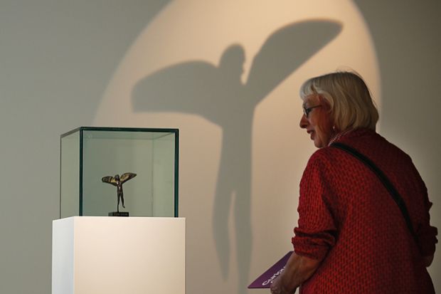A woman looking at an item in a museum