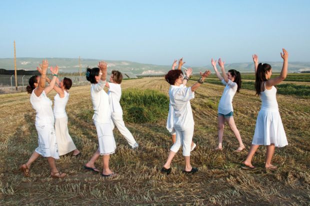 Women dancing in field celebrating Spring Harvest