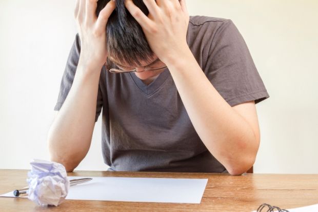 Student holding head in hands