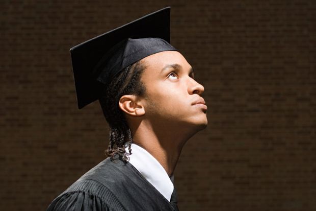 Young male student in graduation cap and gown