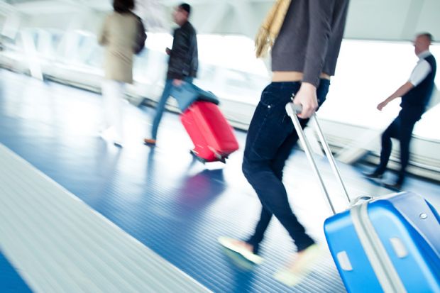 Young male student walking to airport departure lounge