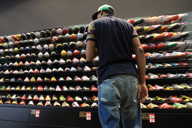 Young man looking at store display of sneakers/trainers