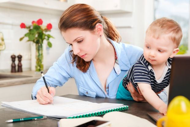 Young mother studying at home with baby