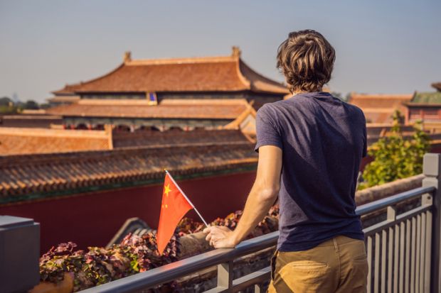 Young man with national chinese flag in Forbidden City