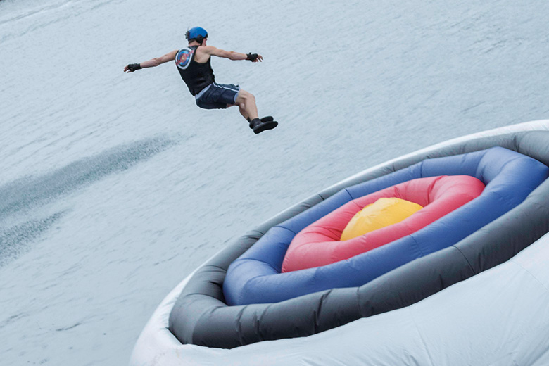A man jumping on to a giant inflatable target in water