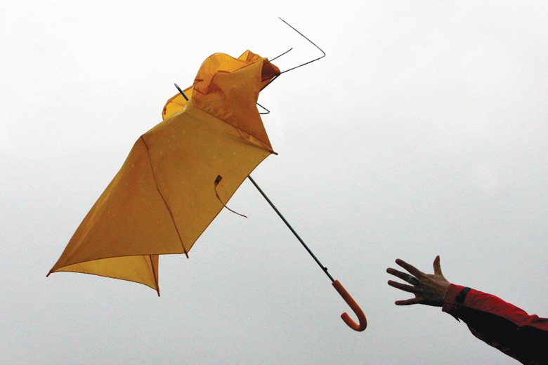 Umbrella pulled from hand in gust of wind