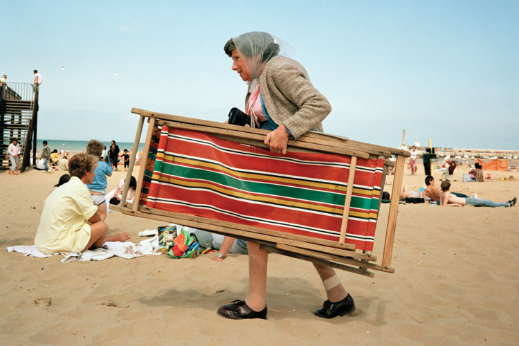 Woman carrying deckchair, Margate beach, England
