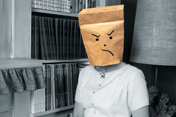 Woman wearing angry-faced paper bag mask