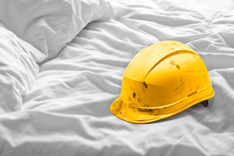 Worksite hard hat lying on bed